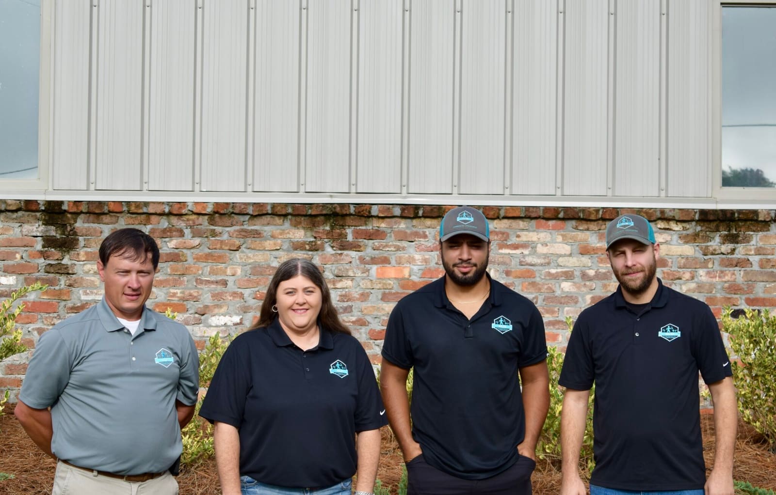Four ALM team members in company shirts