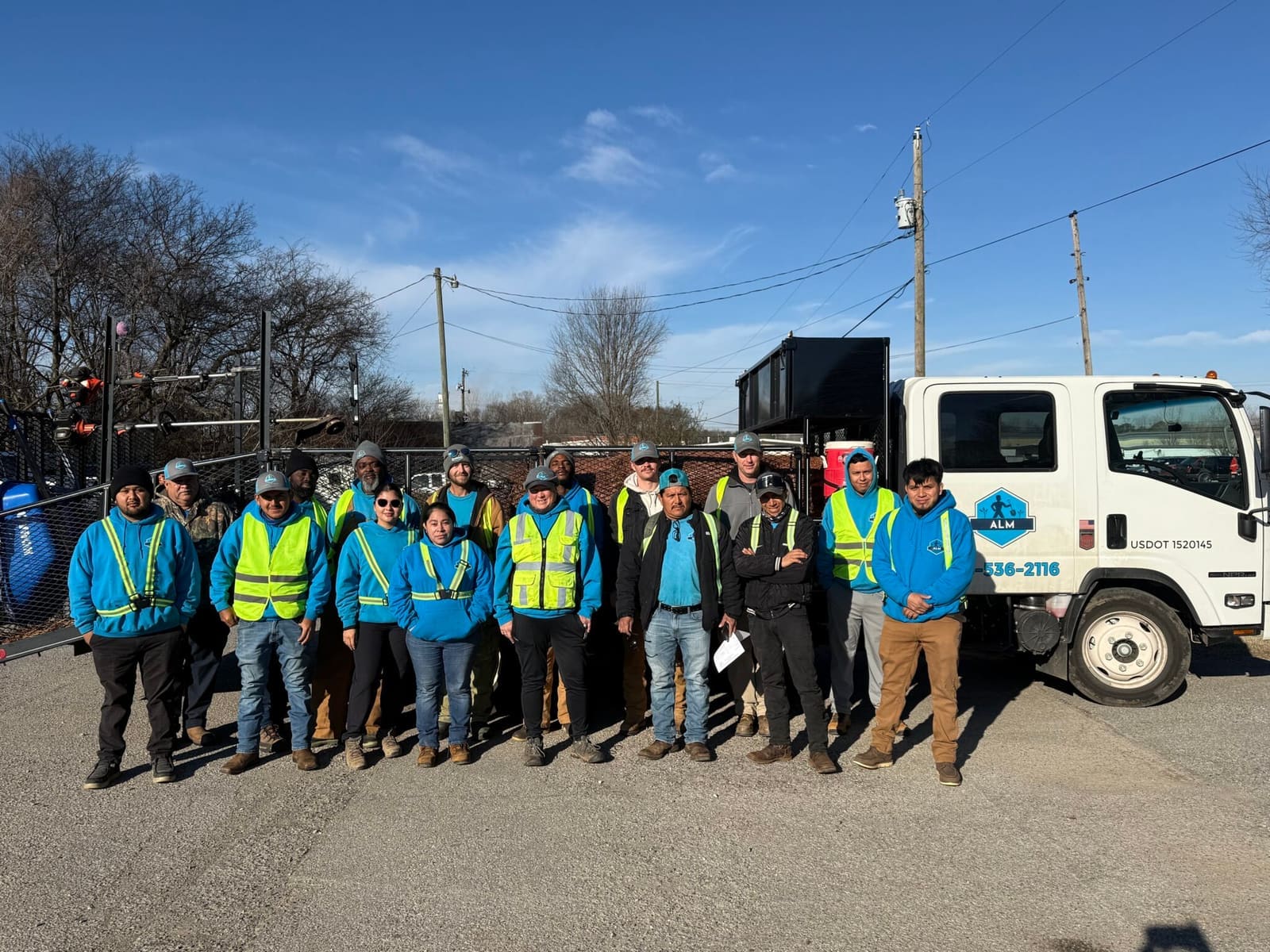 ALM crew in safety vests beside a company truck